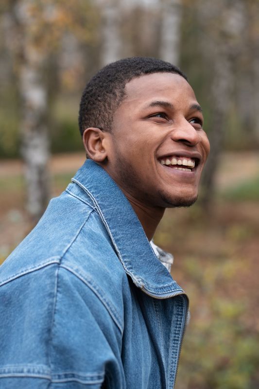 Lachender Mann in Jeansjacke, Outdoor-Portrait