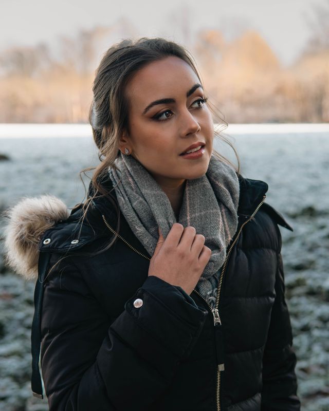 Frau in Winterjacke auf frostiger Wiese